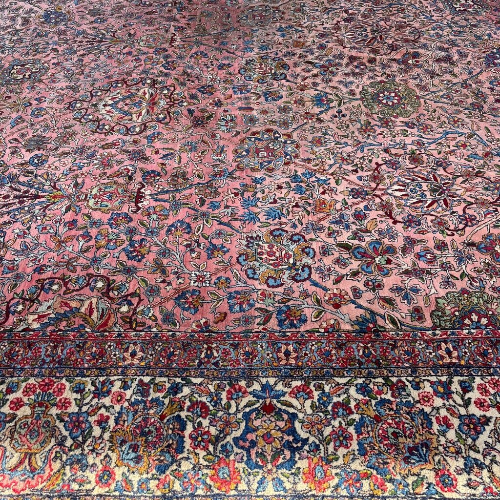Early 20th Century Kerman Lavar Persian Rug, Hand-Knotted in Iran. Rose Field w/ Ivory Border Accented in Blue and Green. Fine Wool Pile on Cotton Foundation. Classic Overscale Room Size. Measures 11.06Lx19.01W. Circa 1920s.