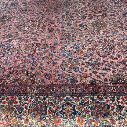 Early 20th Century Kerman Lavar Persian Rug, Hand-Knotted in Iran. Rose Field w/ Ivory Border Accented in Blue and Green. Fine Wool Pile on Cotton Foundation. Classic Overscale Room Size. Measures 11.06Lx19.01W. Circa 1920s.